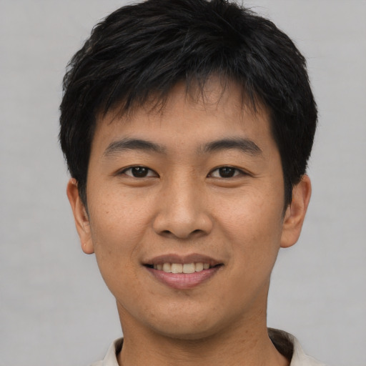 Joyful asian young-adult male with short  brown hair and brown eyes