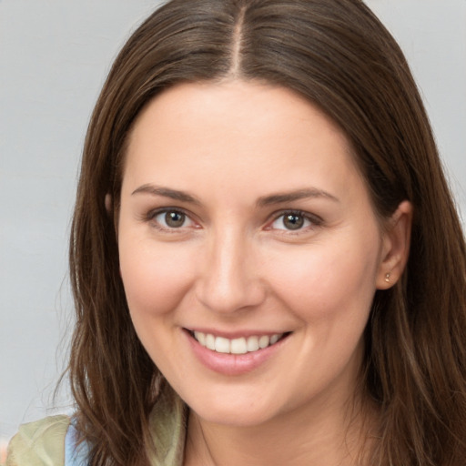 Joyful white young-adult female with long  brown hair and brown eyes