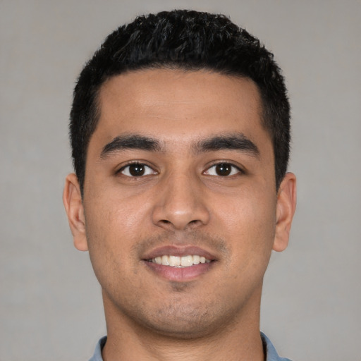 Joyful latino young-adult male with short  black hair and brown eyes