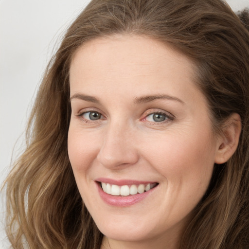 Joyful white young-adult female with long  brown hair and blue eyes