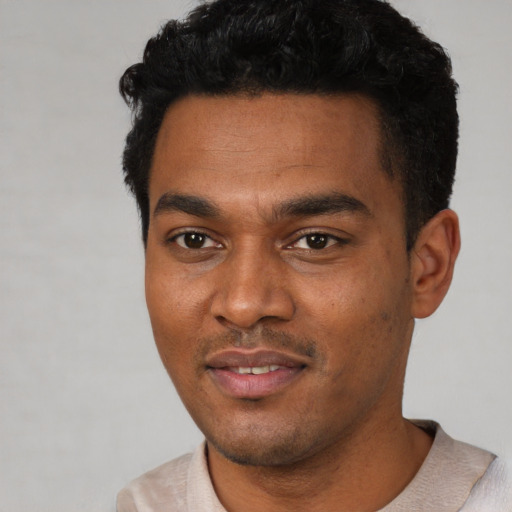Joyful black young-adult male with short  black hair and brown eyes