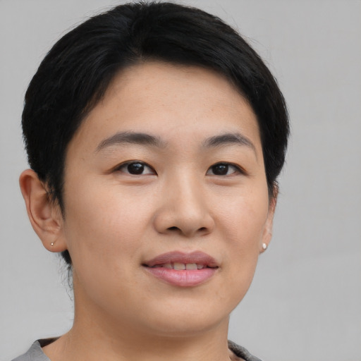 Joyful asian young-adult female with short  black hair and brown eyes