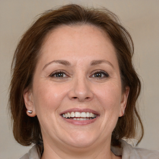 Joyful white adult female with medium  brown hair and grey eyes