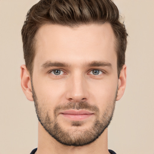 Joyful white young-adult male with short  brown hair and grey eyes