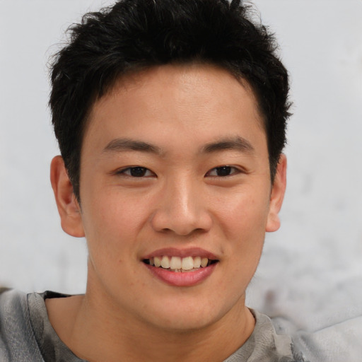 Joyful asian young-adult male with short  brown hair and brown eyes