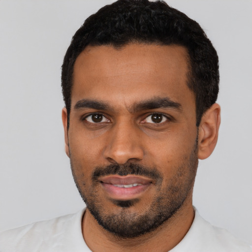Joyful black young-adult male with short  black hair and brown eyes