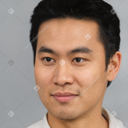 Joyful asian young-adult male with short  black hair and brown eyes