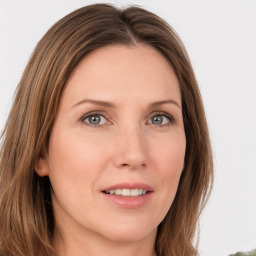 Joyful white young-adult female with long  brown hair and green eyes