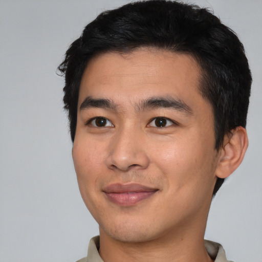 Joyful asian young-adult male with short  black hair and brown eyes