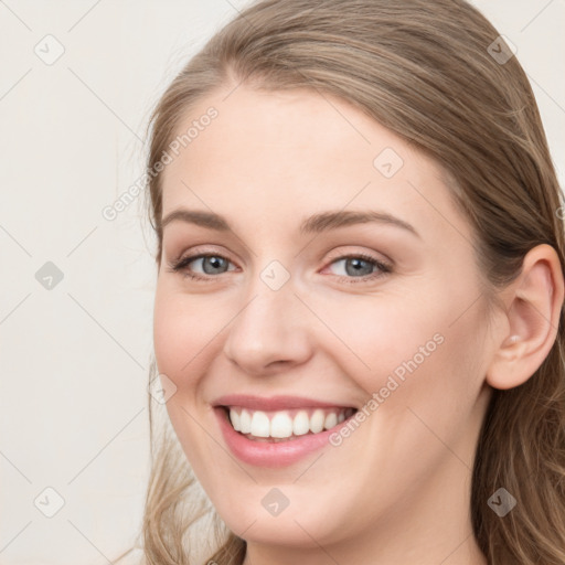 Joyful white young-adult female with long  brown hair and blue eyes