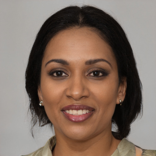 Joyful black young-adult female with medium  brown hair and brown eyes