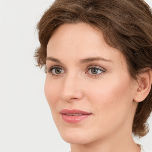 Joyful white young-adult female with medium  brown hair and green eyes