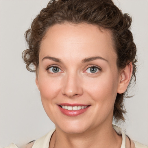 Joyful white young-adult female with medium  brown hair and blue eyes