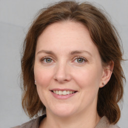 Joyful white adult female with medium  brown hair and grey eyes