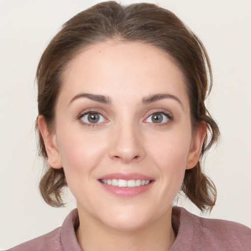 Joyful white young-adult female with medium  brown hair and grey eyes