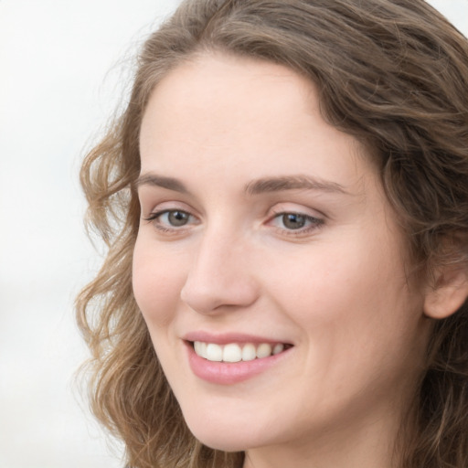 Joyful white young-adult female with long  brown hair and green eyes