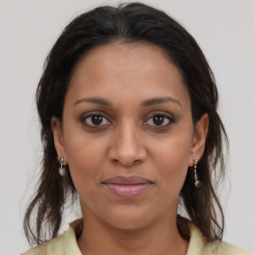 Joyful black young-adult female with long  brown hair and brown eyes