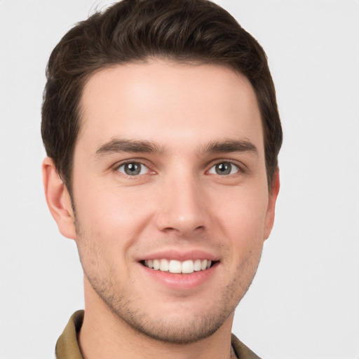 Joyful white young-adult male with short  brown hair and grey eyes