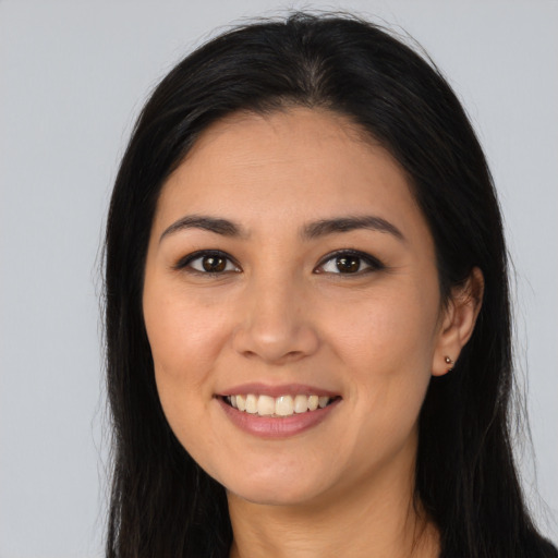 Joyful latino young-adult female with long  brown hair and brown eyes