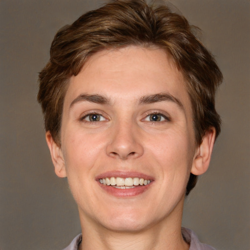 Joyful white young-adult female with short  brown hair and green eyes