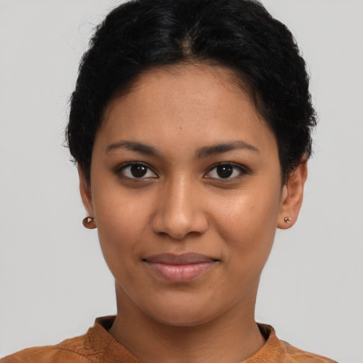 Joyful latino young-adult female with short  black hair and brown eyes