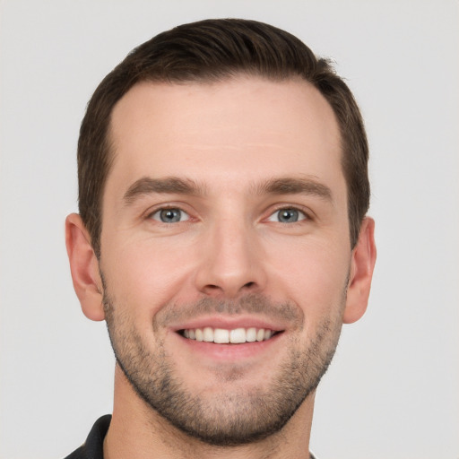 Joyful white young-adult male with short  brown hair and grey eyes