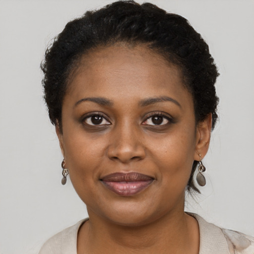 Joyful black young-adult female with short  brown hair and brown eyes