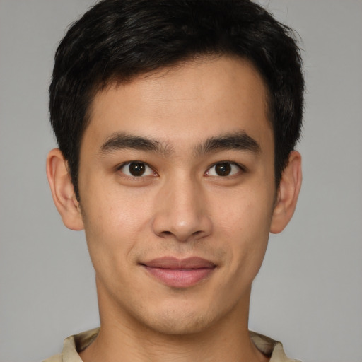 Joyful latino young-adult male with short  brown hair and brown eyes