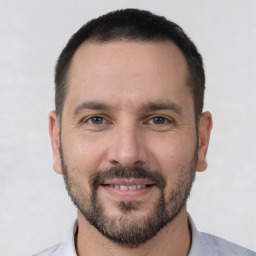 Joyful white adult male with short  brown hair and brown eyes