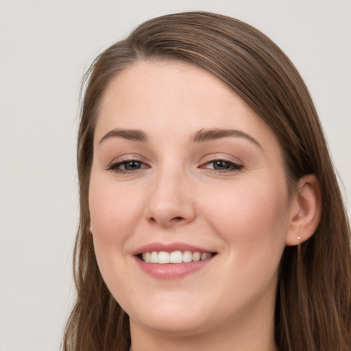 Joyful white young-adult female with long  brown hair and grey eyes