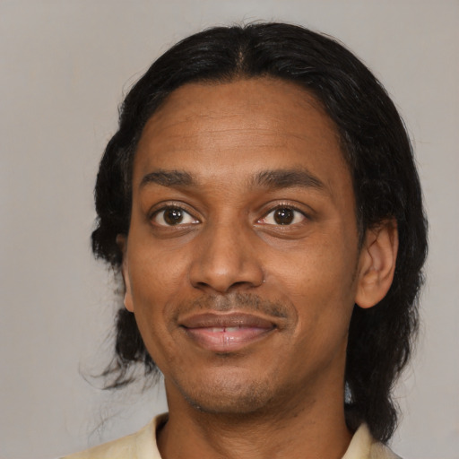 Joyful black adult male with medium  black hair and brown eyes