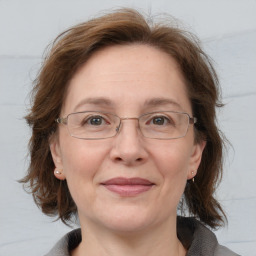 Joyful white adult female with medium  brown hair and blue eyes