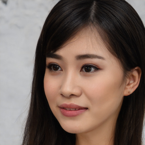 Joyful asian young-adult female with long  brown hair and brown eyes