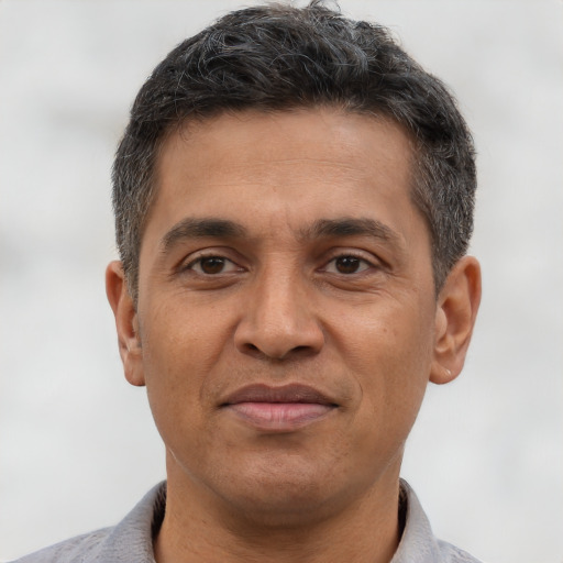 Joyful latino adult male with short  brown hair and brown eyes