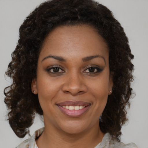 Joyful black young-adult female with medium  brown hair and brown eyes
