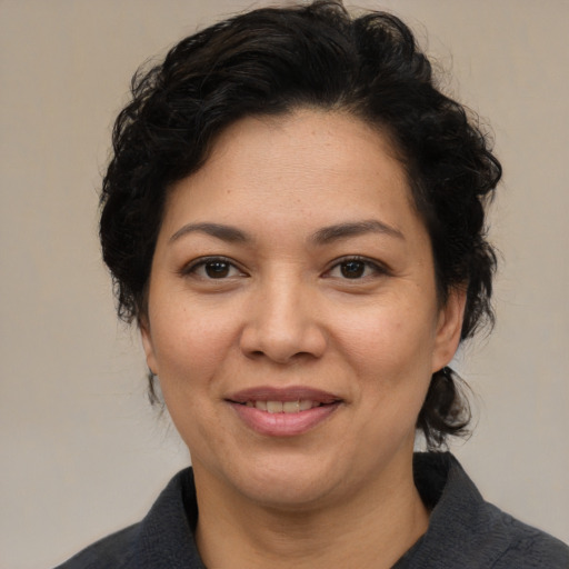 Joyful latino adult female with medium  brown hair and brown eyes