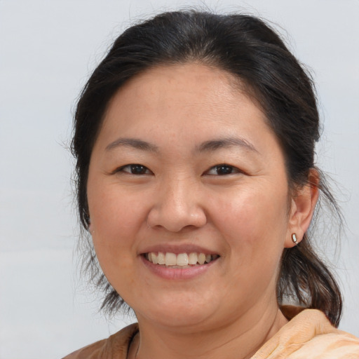 Joyful asian adult female with medium  brown hair and brown eyes