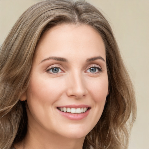 Joyful white young-adult female with long  brown hair and green eyes