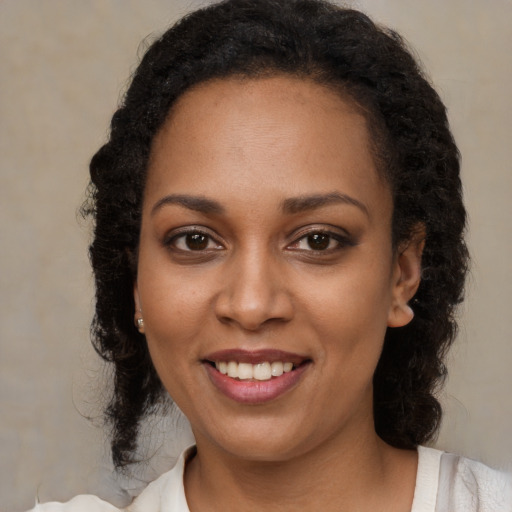 Joyful black young-adult female with medium  brown hair and brown eyes