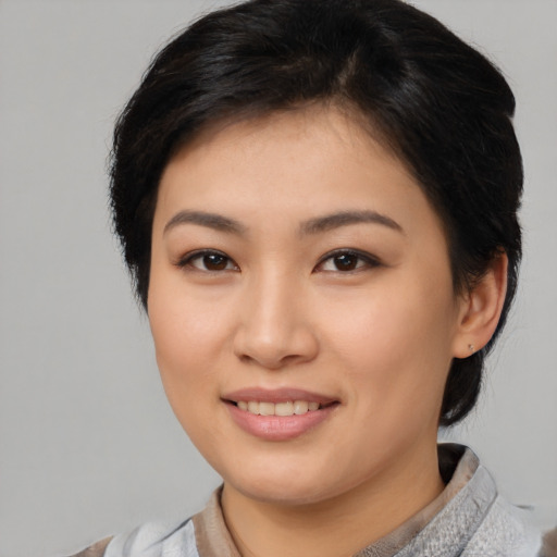 Joyful asian young-adult female with short  brown hair and brown eyes