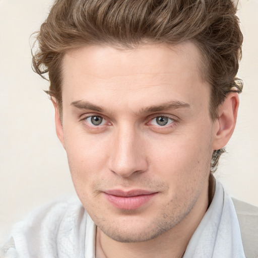 Joyful white young-adult male with short  brown hair and blue eyes