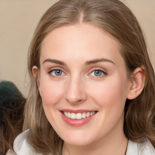 Joyful white young-adult female with medium  brown hair and blue eyes