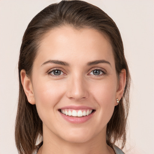 Joyful white young-adult female with medium  brown hair and grey eyes