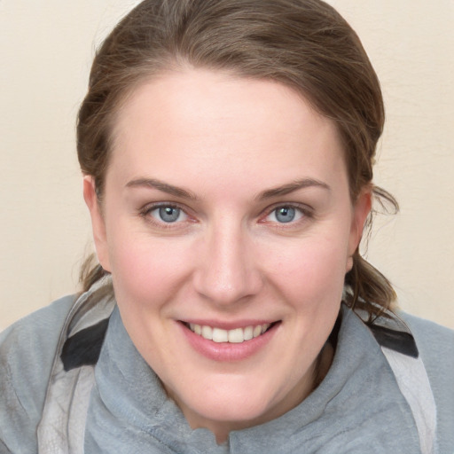 Joyful white young-adult female with medium  brown hair and blue eyes