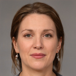 Joyful white adult female with medium  brown hair and grey eyes