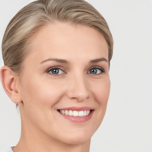 Joyful white young-adult female with short  brown hair and blue eyes