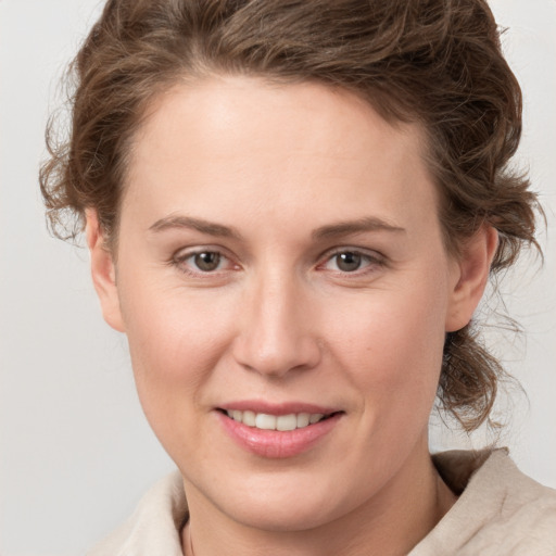 Joyful white young-adult female with medium  brown hair and grey eyes