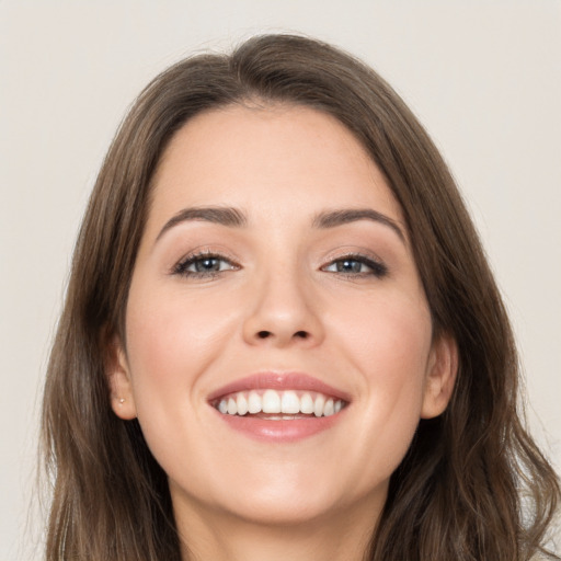 Joyful white young-adult female with long  brown hair and grey eyes