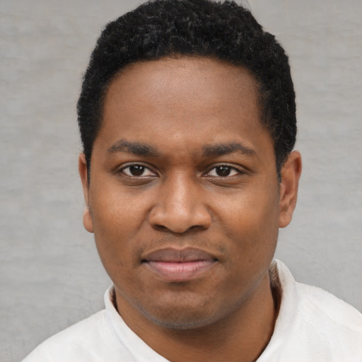 Joyful black young-adult male with short  black hair and brown eyes