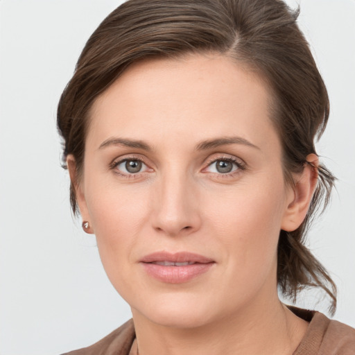 Joyful white young-adult female with medium  brown hair and grey eyes